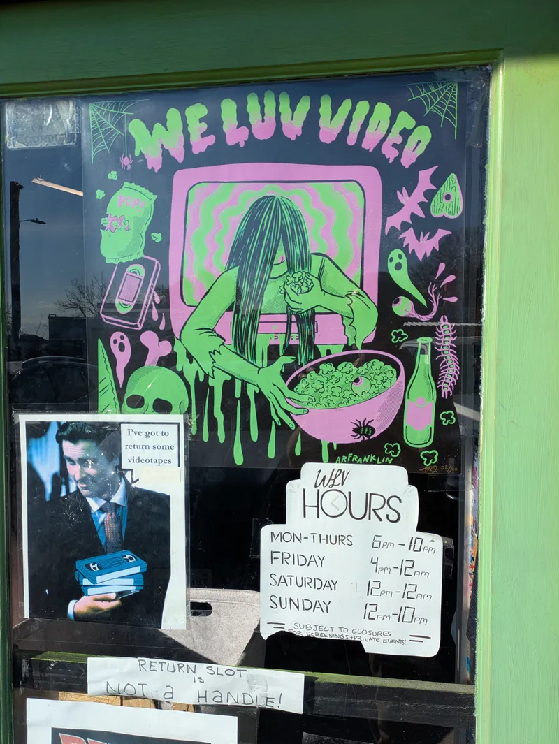 Window display for "We Luv Video" featuring a drawing of a long-haired figure and movie-related graphics.