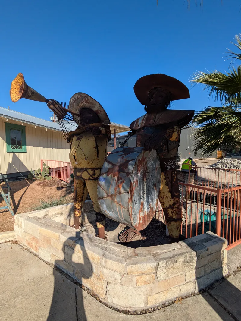 Two metal sculptures of mariachi players.