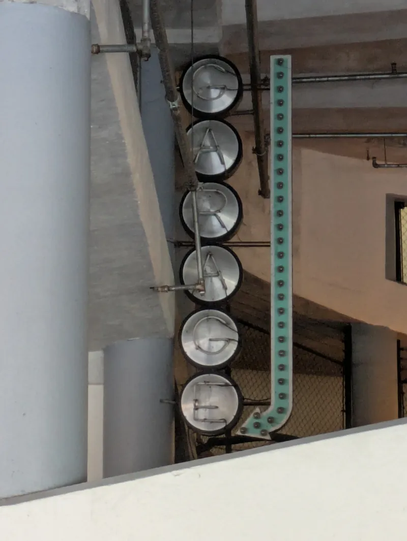 A vertical sign spelling out "GRAGE" with metal letters on circular bases.
