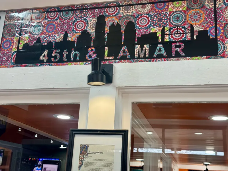 Colorful mandala-patterned wallpaper behind a black skyline silhouette and "45th & Lamar" text.