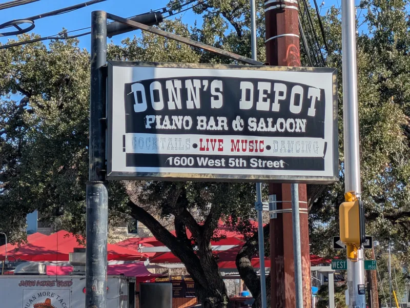Sign for Donn's Depot Piano Bar & Saloon, advertising cocktails, live music, and dancing at 1600 West 5th Street.