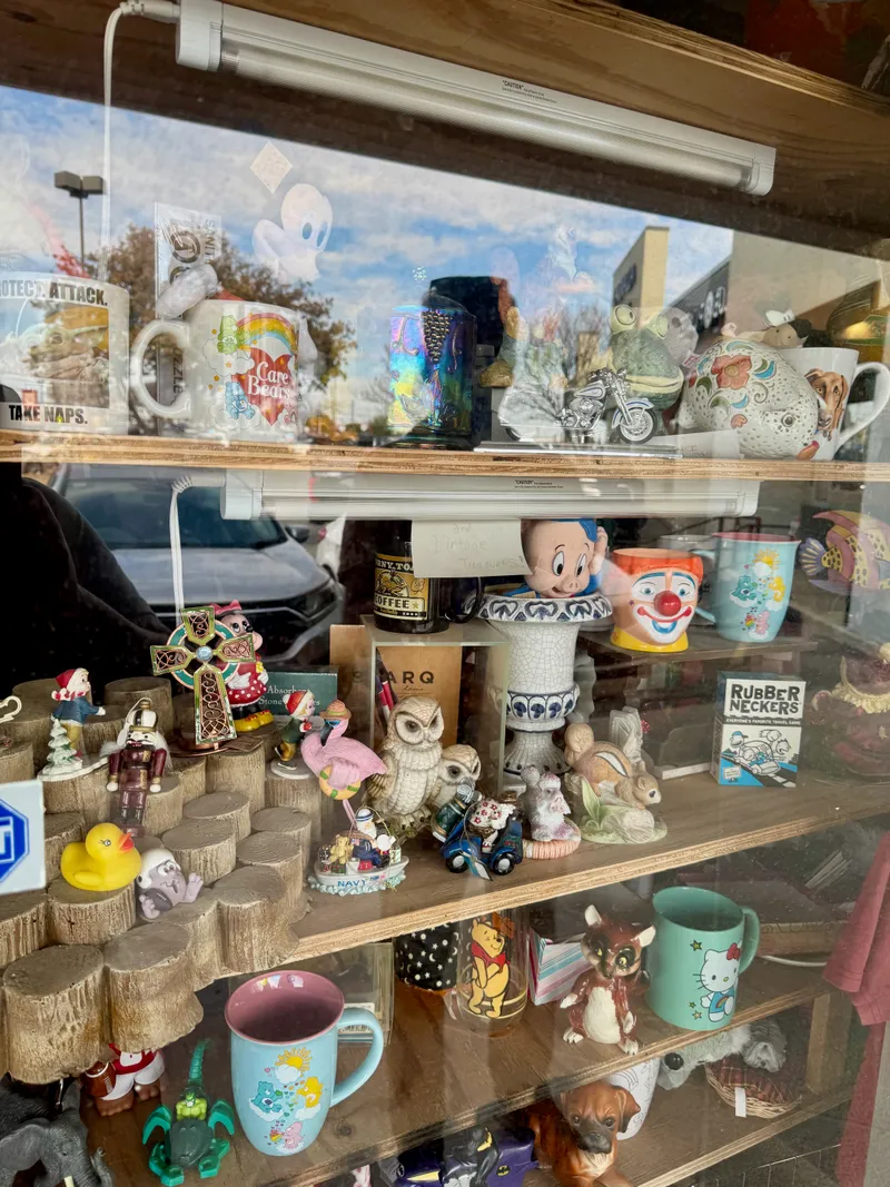 A display window filled with various collectible figurines, mugs, and trinkets.