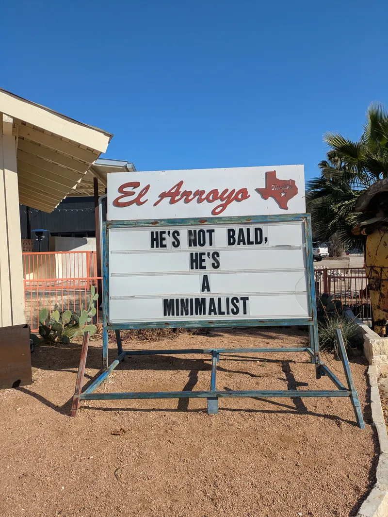A signsaying El Arroyo with the phrase He's not bald, he's a minimalist.