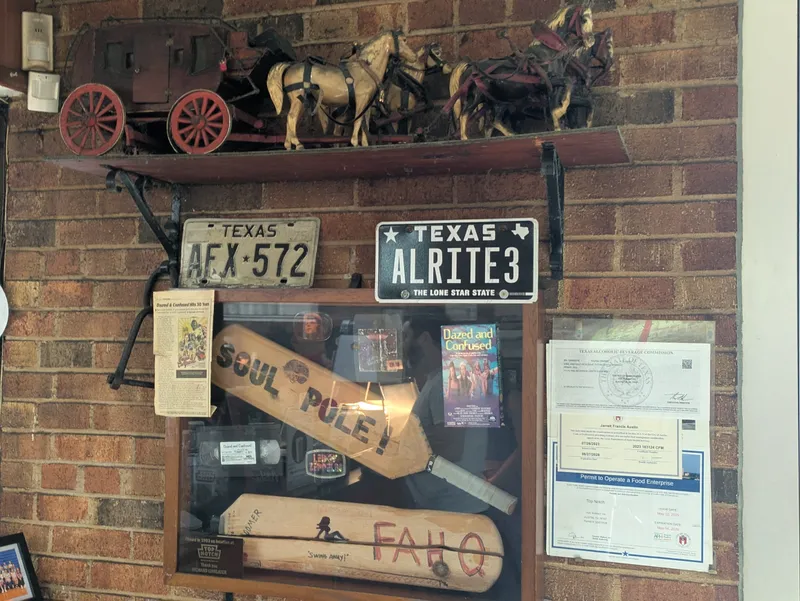 Display case with baseball bats, license plates, and movie memorabilia including Dazed and Confused.