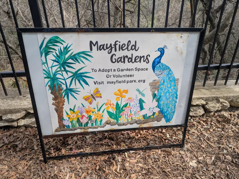 Sign for Mayfield Gardens with a peacock and flowers, inviting visitors to adopt a garden space or volunteer.