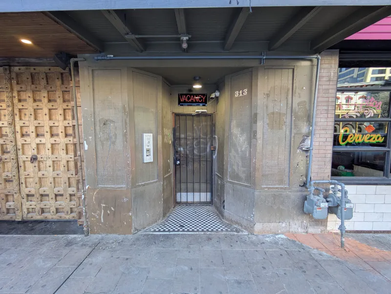 Entrance to a venue with a "VACANCY" sign and a decorative wooden door next to it.